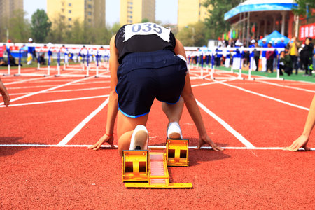 The athletes are at the starting line of the stadium