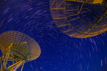 In observatories,satellite antenna radio telescope on the background of stellar tracks