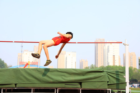 A male athlete is on the high jumpの写真素材