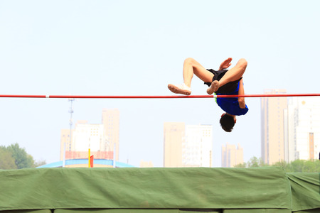 A male athlete is on the high jumpの写真素材