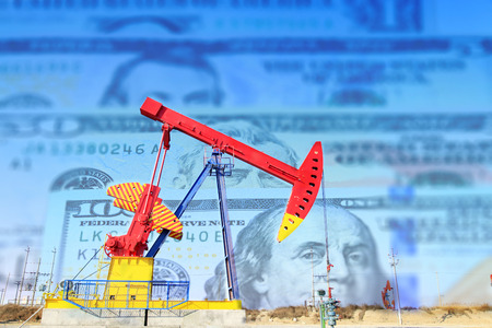 Petroleum, petrodollar and crude oil concept, Oil pump on background of US dollar, Dollars and oil pumpsの写真素材
