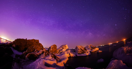 On winter nights, snow and ice cover the rocks by the sea