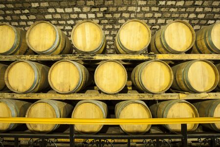 Wine barrels stacked in the cellar of the wineryの写真素材