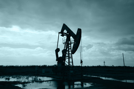 Oil field site, in the evening, oil pumps are running