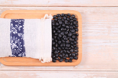 The black beans are on the wooden table