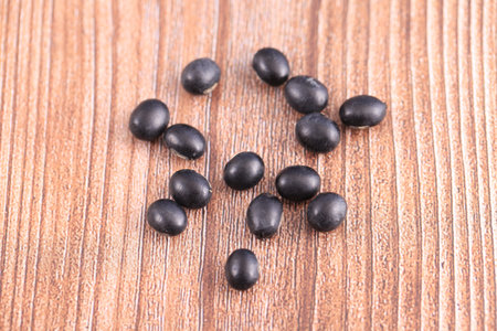 The black beans are on the wooden table