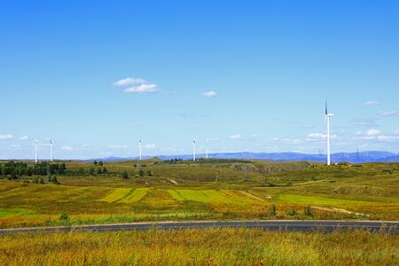 Asphalt road and wind turbinesの写真素材