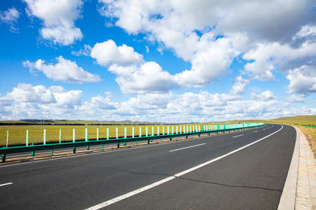 Empty highway, blue sky and white clouds landscapeの写真素材