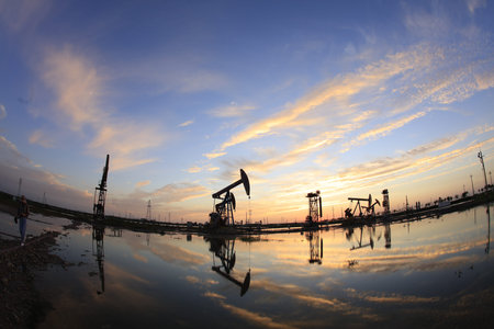 Oil field site, in the evening, oil pumps are running, The oil pump and the beautiful sunset...