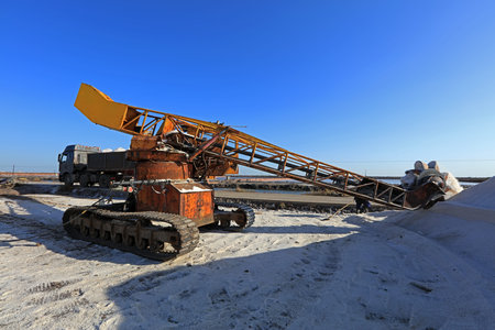 machine placing the harvested and washed salt on a conveyor belt. Salt production equipment, The...