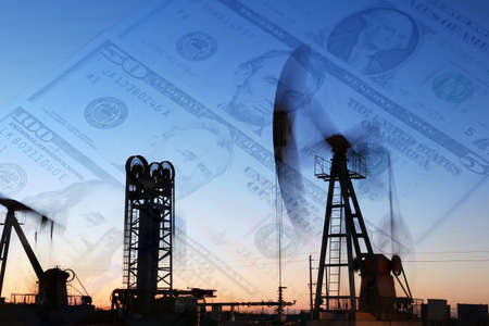 Petroleum, petrodollar and crude oil concept, Oil pump on background of US dollar, Dollars and oil pumpsの写真素材