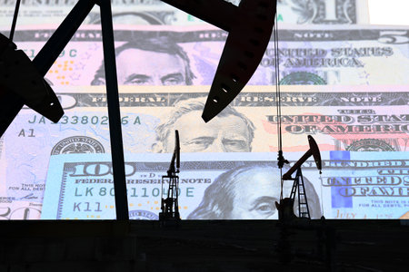 Petroleum, petrodollar and crude oil concept, Oil pump on background of US dollar, Dollars and oil pumpsの写真素材