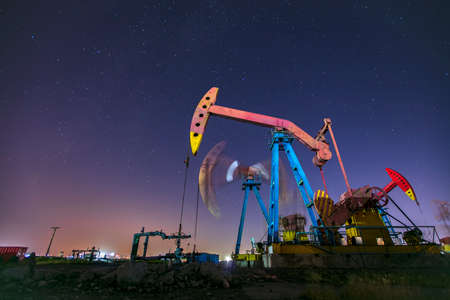 At night, oil pumps under the stars, Oil fields under the starsの写真素材