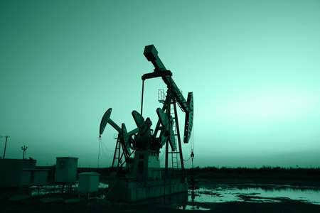 Oil field site, in the evening, oil pumps are runningの写真素材