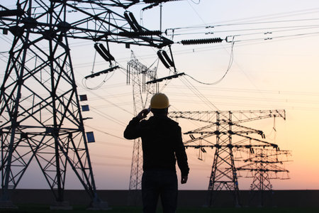 In the evening, electricity workers and pylon silhouette, Power workers at work