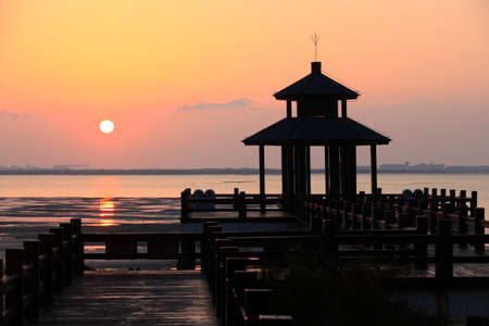 Sunrise by the sea. Wooden pavilions by the sea at sunrise in the morning. A pavilion by the sea watching the sunriseの写真素材
