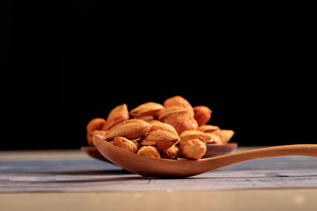 Badam, almonds is on the wooden table, close-up