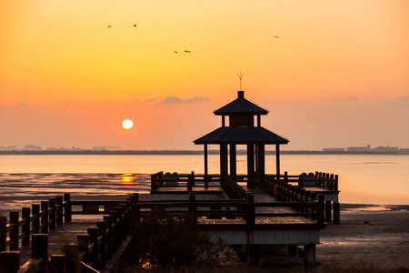 Sunrise by the sea. Wooden pavilions by the sea at sunrise in the morning. A pavilion by the sea watching the sunriseの写真素材
