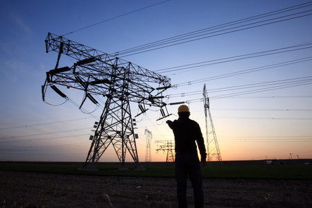 In the evening, electricity workers and pylon silhouette, Power workers at work