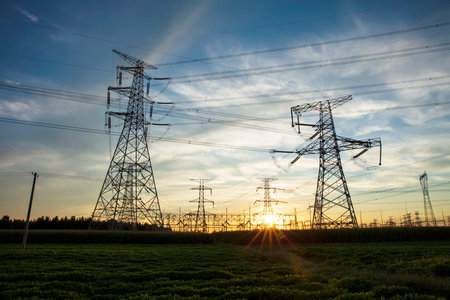 In the evening, high voltage towers silhouette and a beautiful sunset