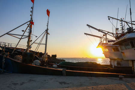 Wooden fishing boats on the coast in the evening, Beautiful seaside sunsetの写真素材