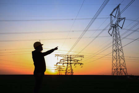 In the evening, electricity workers and pylon silhouette, Power workers at workの写真素材