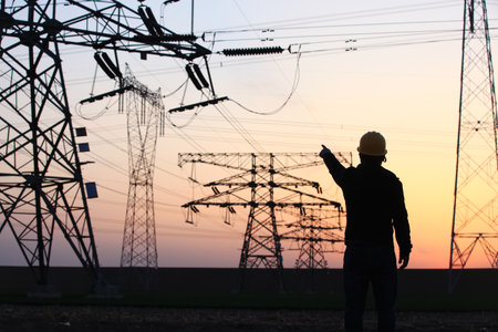 In the evening, electricity workers and pylon silhouette, Power workers at workの写真素材