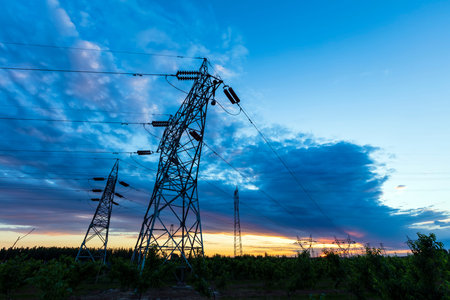 In the evening, high voltage towers silhouette and a beautiful sunset