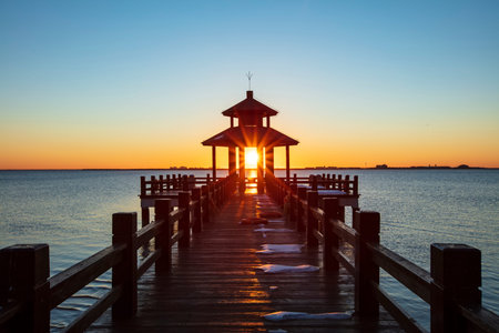 Sunrise by the sea. Wooden pavilions by the sea at sunrise in the morning. A pavilion by the sea watching the sunriseの写真素材