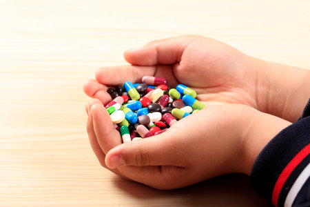 Colorful pills and medicines in the hand, A handful of various pills in a woman's handsの写真素材