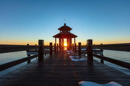 Sunrise by the sea. Wooden pavilions by the sea at sunrise in the morning. A pavilion by the sea watching the sunriseの写真素材