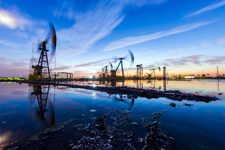 Oil field site, in the evening, oil pumps are running, The oil pump and the beautiful sunset...