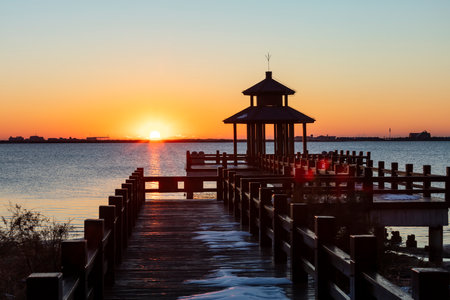 Sunrise by the sea. Wooden pavilions by the sea at sunrise in the morning. A pavilion by the sea watching the sunriseの写真素材