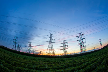 In the evening, high voltage towers silhouette and a beautiful sunsetの写真素材