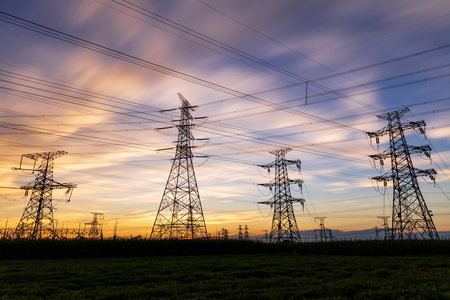 In the evening, high voltage towers silhouette and a beautiful sunsetの写真素材