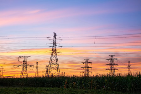 In the evening, high voltage towers silhouette and a beautiful sunset