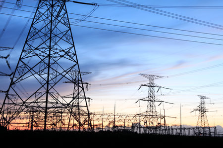 In the evening, high voltage towers silhouette and a beautiful sunsetの写真素材