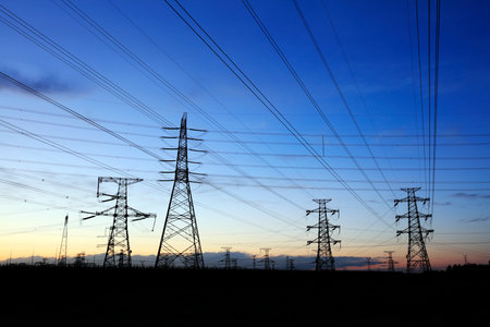 In the evening, high voltage towers silhouette and a beautiful sunsetの写真素材