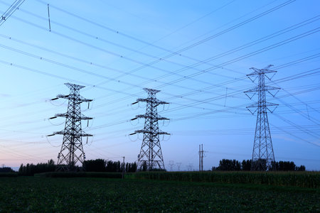 In the evening, high voltage towers silhouette and a beautiful sunsetの写真素材