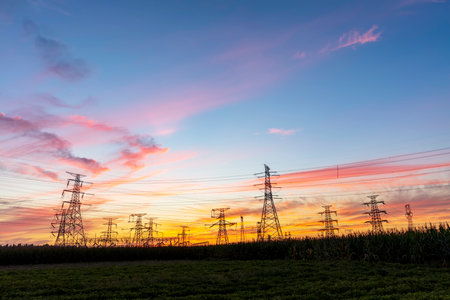 In the evening, high voltage towers silhouette and a beautiful sunsetの写真素材