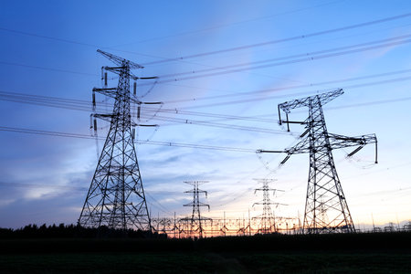 In the evening, high voltage towers silhouette and a beautiful sunsetの写真素材