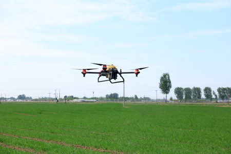 High-resolution photographic images of industrial drones spraying drugs on rice paddies and fields. Drug spraying using a drone concept. Smart agriculture.の写真素材