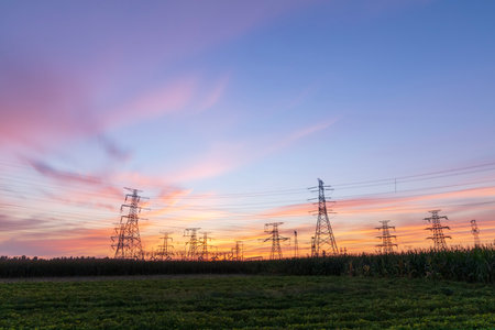 In the evening, high voltage towers silhouette and a beautiful sunsetの写真素材