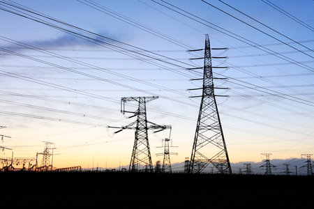 In the evening, high voltage towers silhouette and a beautiful sunsetの写真素材