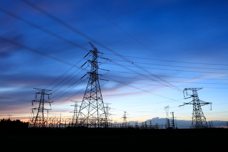 In the evening, high voltage towers silhouette and a beautiful sunsetの写真素材