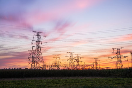 In the evening, high voltage towers silhouette and a beautiful sunsetの写真素材