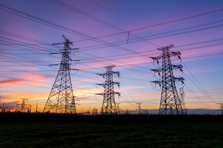 In the evening, high voltage towers silhouette and a beautiful sunsetの写真素材