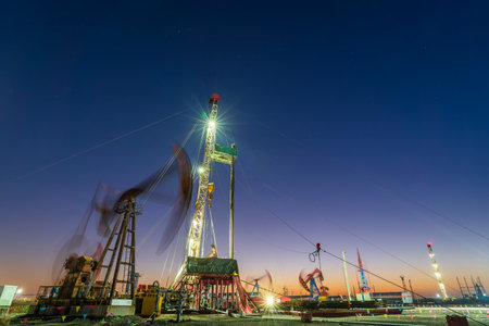 Oil field, oil drilling rig in the eveningの写真素材