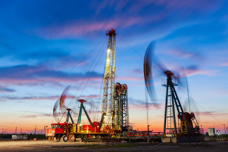 Oil field site, in the evening, oil pumps are running, The oil pump and the beautiful sunset...