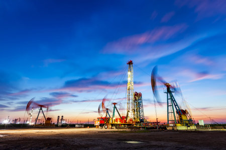 Oil field site, in the evening, oil pumps are running, The oil pump and the beautiful sunset...